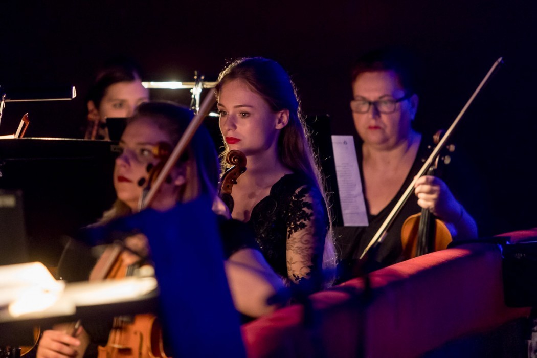 Grupa kobiet grająca na instrumentach w eleganckich strojach