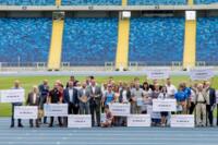 ludzie ustawienia na stadionie z czekami o dużych kwotach