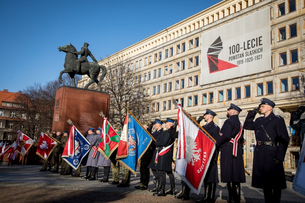 Ludzie stojący z różnorodnymi sztandarami przy Urzędzie Marszałkowskim